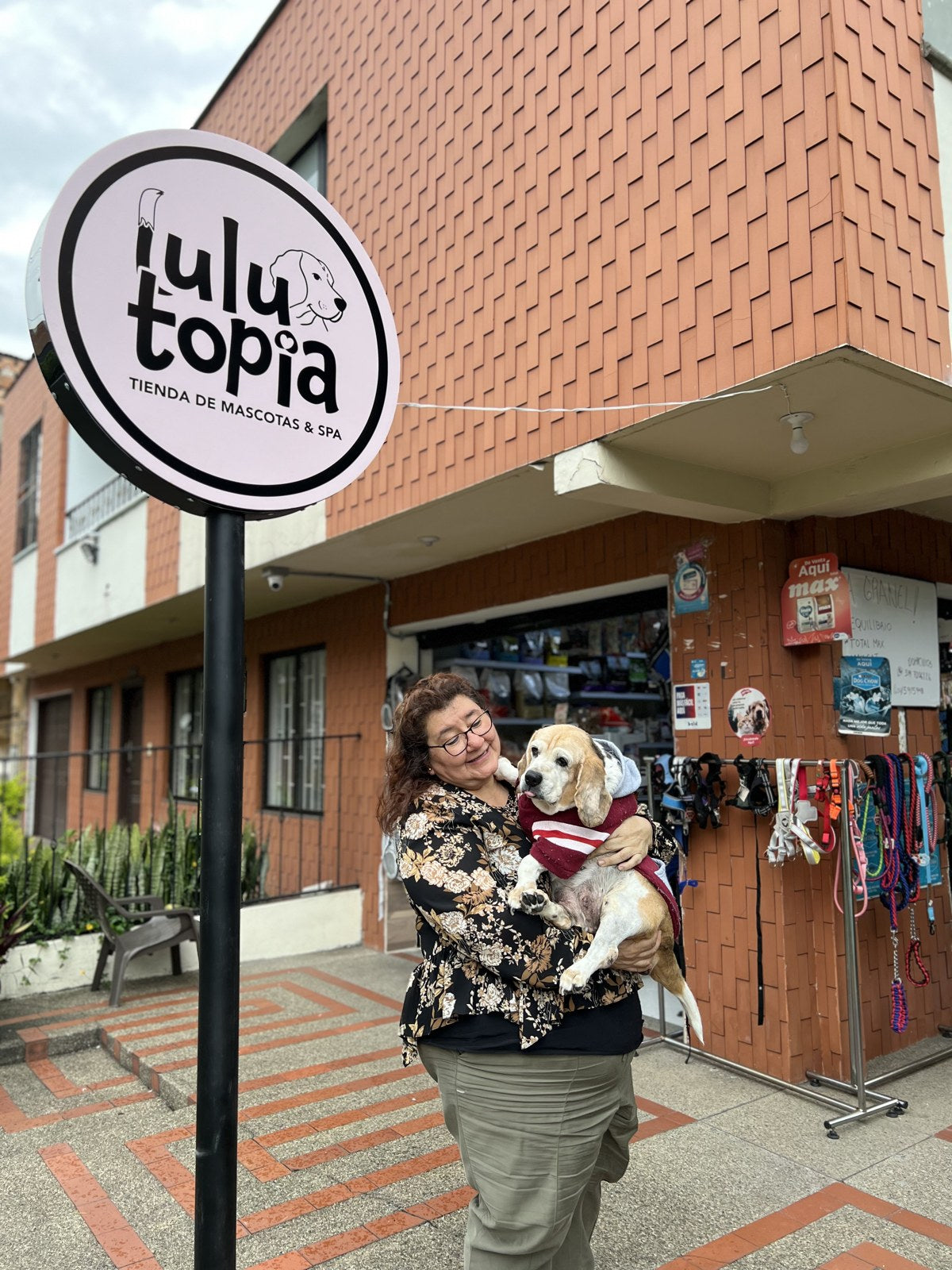 La mamá de Juanes cargando a Lulú frente a la tienda Lulutopia en Medellín